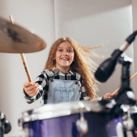 young girl playing drums in music studio