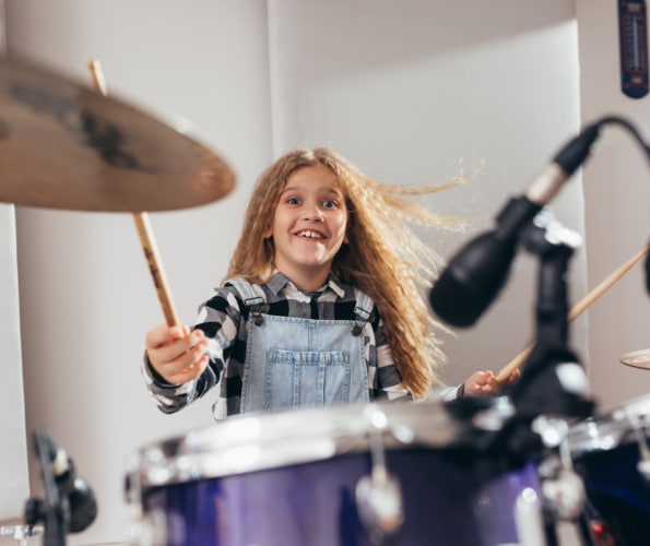 young girl playing drums in music studio